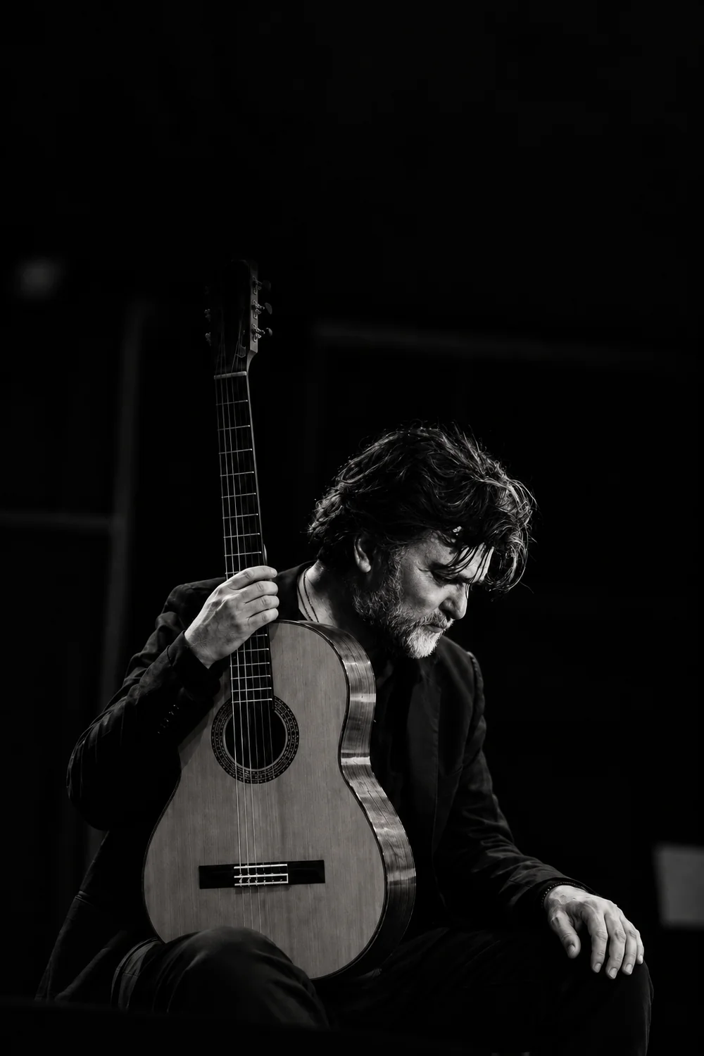 Antonio Segura, portrait mélancolique en clair-obscur avec sa guitare flamenco
